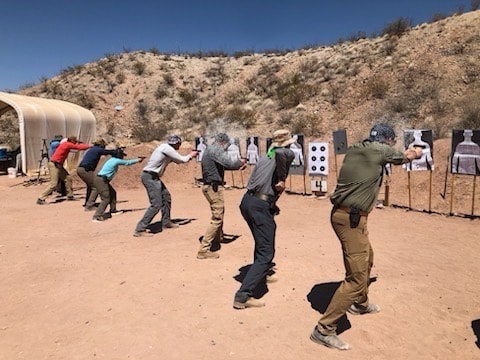 Students shooting at targets during tactical pistol course at Veritus Shooting Group outdoor range