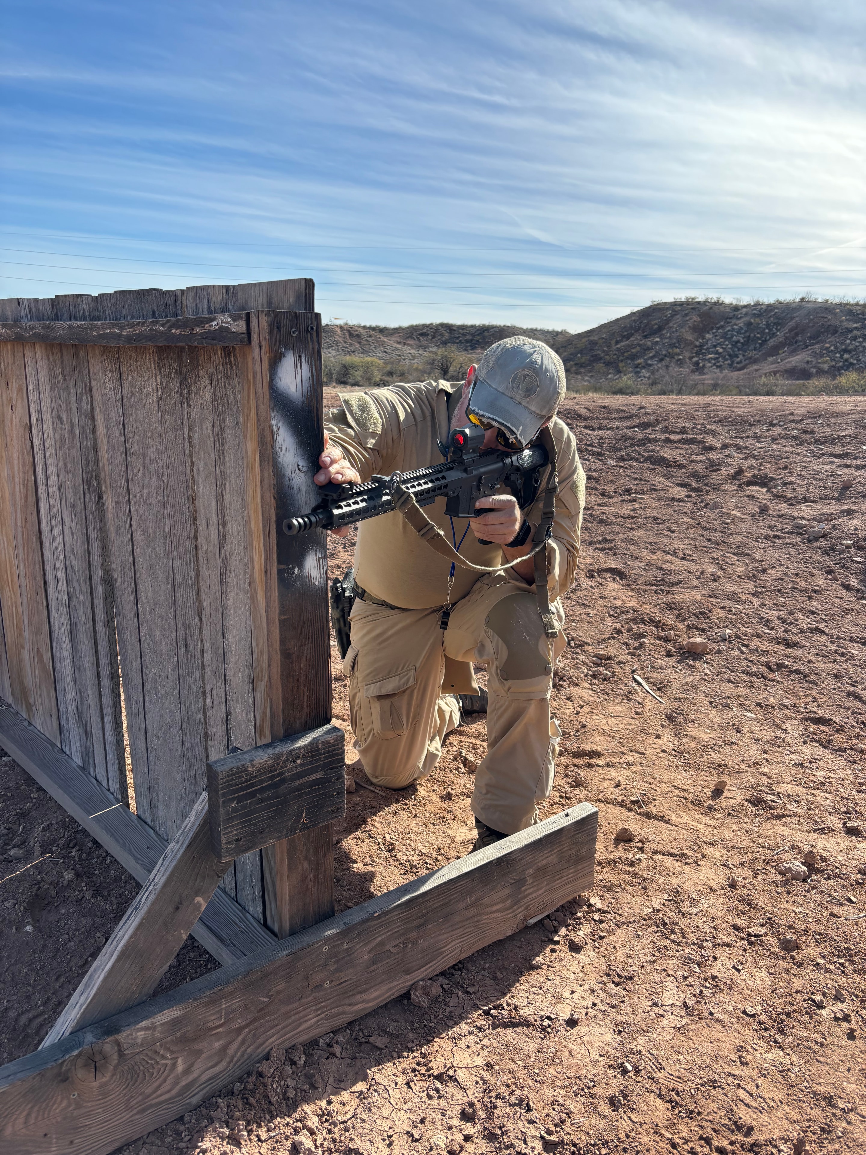 Shooter engaging wooden target at Veritus Shooting Group outdoor tactical training range