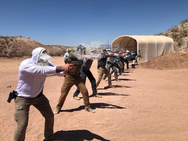 Students lined up on the firing line during group pistol training at Veritus Shooting Group